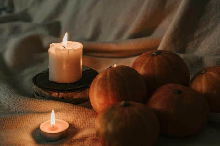 Candles glowing near pumpkins